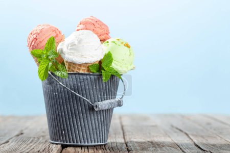 Foto de Varios helados en conos de gofre. Fresa, pistacho y helado de vainilla con espacio para copiar - Imagen libre de derechos
