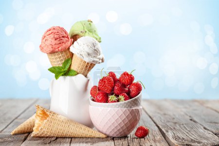 Foto de Varios helados en conos de gofre. Fresa, pistacho y helado de vainilla. Con espacio de copia - Imagen libre de derechos