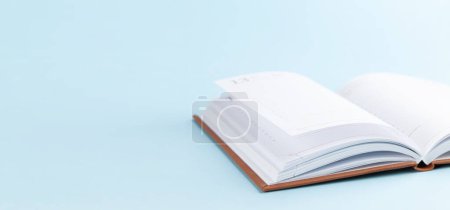 Notepad over blue background with copy space