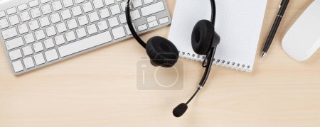 Foto de Escritorio de oficina con auriculares y suministros. Mesa central de llamadas. Top veiw plano laico - Imagen libre de derechos