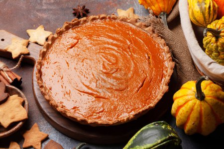 Photo for Homemade pumpkin pie on wooden board and various pumpkins. Top view flat lay - Royalty Free Image