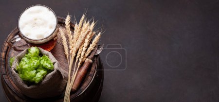 Photo for Lager beer mug, hops and wheat on old wooden barrel. With copy space - Royalty Free Image