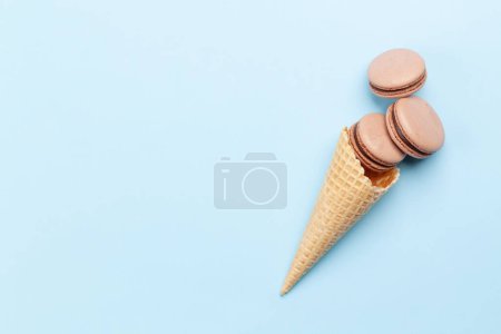 Foto de Varias galletas de macarrones en conos de helado. Piso sobre fondo azul con espacio de copia - Imagen libre de derechos