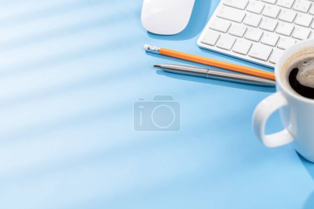 Photo for Top view business office desk with keyboard, office supplies and coffee. Workspace with sunny light and copy space - Royalty Free Image