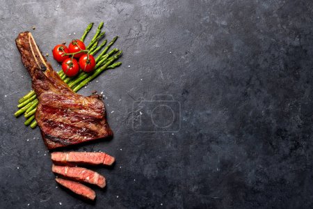 Téléchargez les photos : Bifteck de boeuf Tomahawk grillé moyen et rare aux asperges. Pose plate avec espace de copie - en image libre de droit