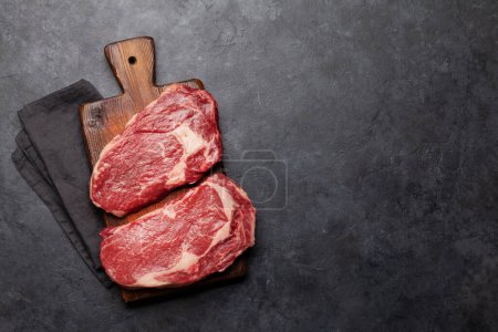 Photo for Two raw ribeye beef steaks. Top view flat lay with copy space - Royalty Free Image