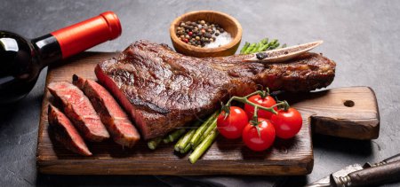 Téléchargez les photos : Bifteck de boeuf Tomahawk grillé moyen et rare avec asperges et vin rouge - en image libre de droit