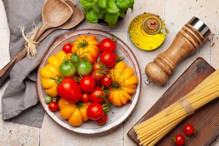 Foto de Varios tomates coloridos del jardín. Verduras frescas y pasta. Vista superior plano laico - Imagen libre de derechos