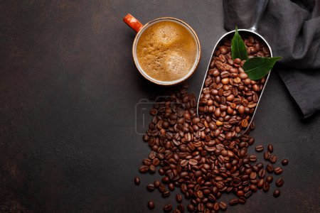 Foto de Granos de café tostados en cucharada y taza de espresso. Piso puesto en la mesa de piedra con espacio de copia - Imagen libre de derechos