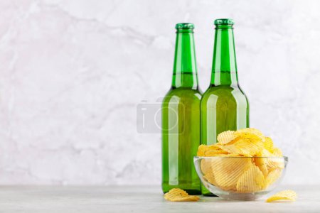 Photo for Beer glass, beer bottles and potato chips. With copy space - Royalty Free Image