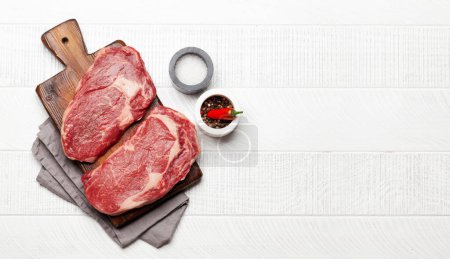 Téléchargez les photos : Deux steaks crus de bœuf. Vue du dessus plat avec espace de copie - en image libre de droit