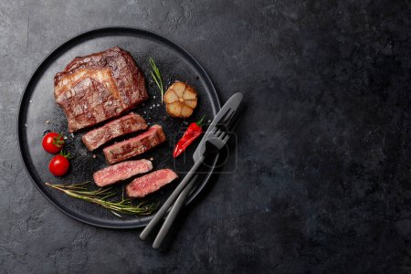Photo for Grilled ribeye beef steak with herbs and spices. Flat lay with copy space - Royalty Free Image