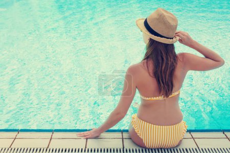 Téléchargez les photos : Jeune femme séduisante se détendre dans la piscine. Avec espace de copie pour votre texte. Sunny tonique - en image libre de droit