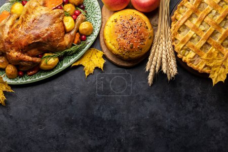 Téléchargez les photos : Dinde d'Action de grâces, tarte aux pommes et pain à la citrouille sur table rustique avec espace de copie. Pose plate - en image libre de droit
