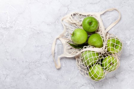 Foto de Manzanas verdes frescas en bolsa de malla. Piso con espacio de copia - Imagen libre de derechos