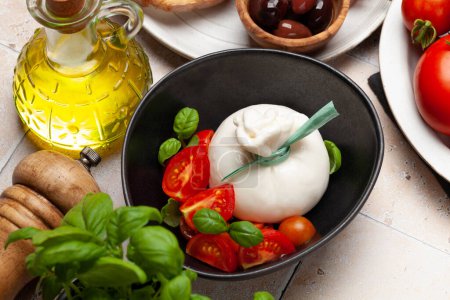 Téléchargez les photos : Fromage burrata, tomates et olives variées. Cuisine italienne - en image libre de droit