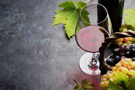 Foto de Vino tinto en copa, botella y uvas en cesta. Con espacio de copia - Imagen libre de derechos