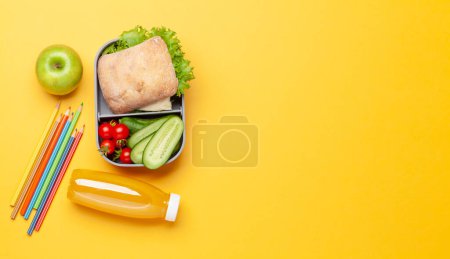 Téléchargez les photos : Boîte à lunch avec sandwich, légumes et jus de fruits. Repas d'école ou de bureau. Pose plate avec espace de copie - en image libre de droit