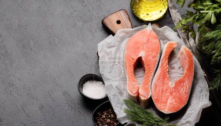 Téléchargez les photos : Fresh salmon steak. Two raw fish steaks and spices. With copy space - en image libre de droit