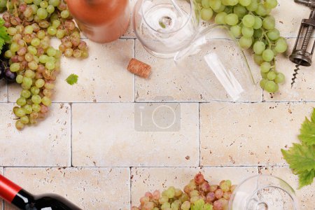 Foto de Botellas de vino blanco, rosa y tinto, uvas y copas. Piso con espacio de copia - Imagen libre de derechos
