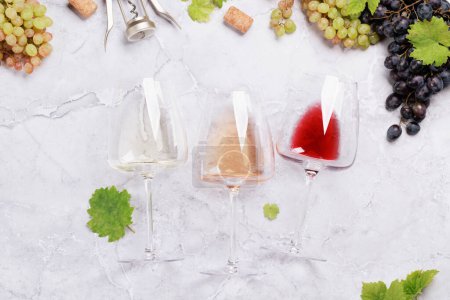 Téléchargez les photos : Verre à vin blanc, rose et rouge et raisin. Pose plate - en image libre de droit