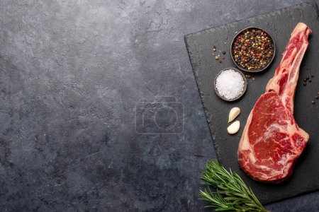 Téléchargez les photos : Raw Tomahawk beef steak and spices. Ready for grilling. Flat lay with copy space - en image libre de droit