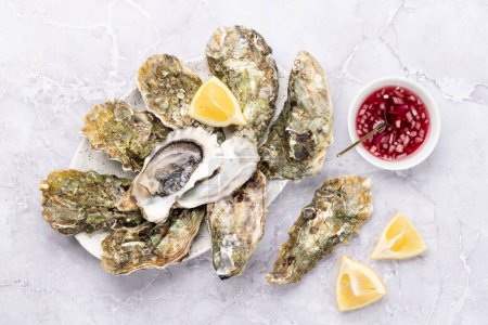 Photo for Fresh oysters with sauce and lemons. Flat lay - Royalty Free Image