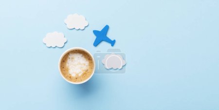 Téléchargez les photos : Concept de voyage et vacances. Café et avion sur bureau bleu avec espace de copie - en image libre de droit