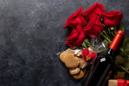 Téléchargez les photos : Carte Saint-Valentin avec bouteille de vin, biscuits en forme de coeur, fleurs roses et espace pour vos salutations - en image libre de droit