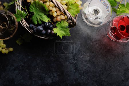 Téléchargez les photos : White, rose and red wine glasses and grape in basket. Flat lay with copy space - en image libre de droit