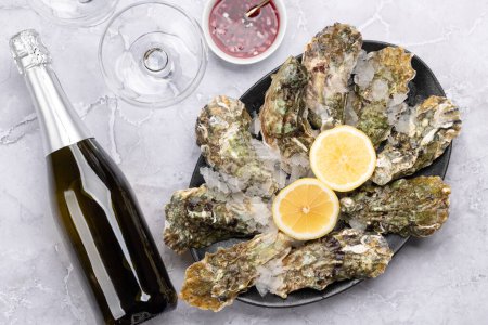 Téléchargez les photos : Huîtres fraîches avec verres de vin mousseux. Pose plate - en image libre de droit