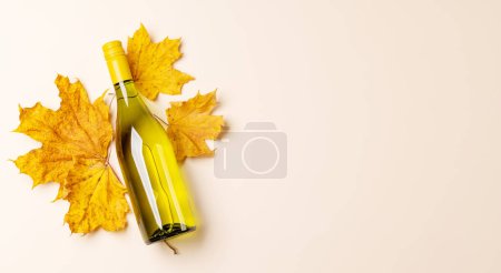 Téléchargez les photos : White wine bottle and autumn leaves. Flat lay with copy space - en image libre de droit