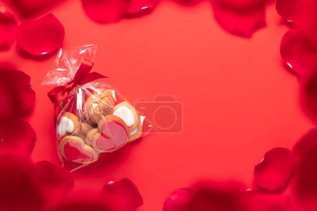 Téléchargez les photos : Biscuits en forme de coeur Saint-Valentin sur fond rouge. Pose plate avec espace de copie - en image libre de droit