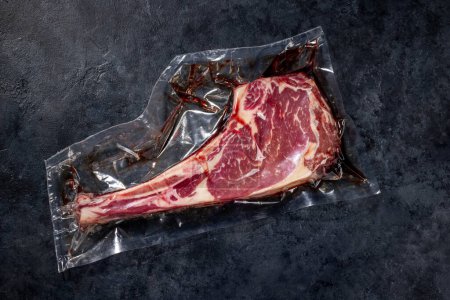 Foto de Raw Tomahawk beef steak vacuum packed. Ready for grilling. Flat lay - Imagen libre de derechos