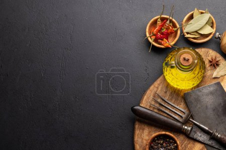 Photo for Various dried spices, olive oil and cooking utensils on wooden board - Royalty Free Image