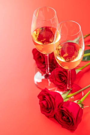 Foto de Tarjeta de San Valentín con champán y rosas. Sobre fondo rojo con espacio para tus saludos - Imagen libre de derechos
