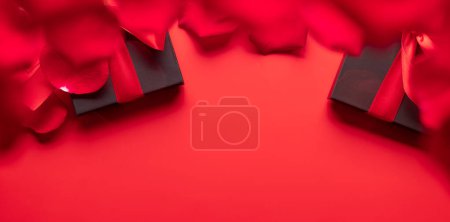 Photo for Valentines day card with gift boxes and rose petals. On red background with space for your greetings - Royalty Free Image