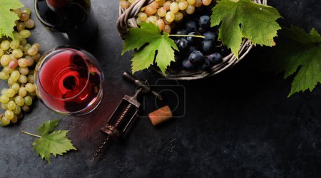 Téléchargez les photos : Verre à vin rouge et raisin dans le panier. Pose plate avec espace de copie - en image libre de droit