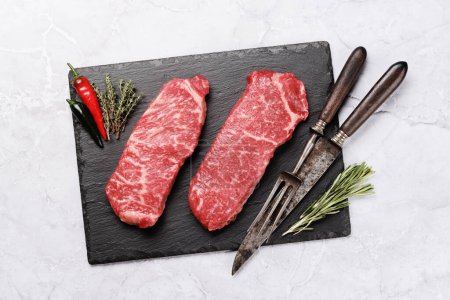 Téléchargez les photos : Des steaks de bœuf marbrés. Bifteck d'aloyau cru. Pose plate - en image libre de droit