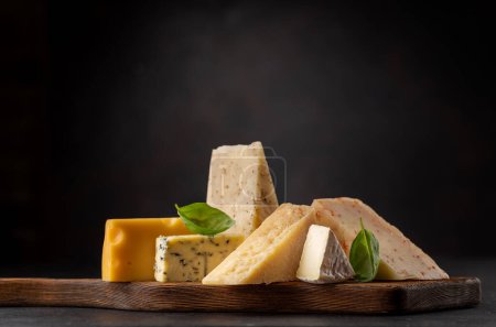 Foto de Various cheese on board on stone table - Imagen libre de derechos