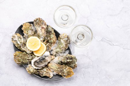 Téléchargez les photos : Huîtres fraîches avec verres de vin mousseux. Pose plate avec espace de copie - en image libre de droit