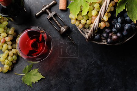 Foto de Copa de vino tinto y uva en cesta. Piso con espacio de copia - Imagen libre de derechos