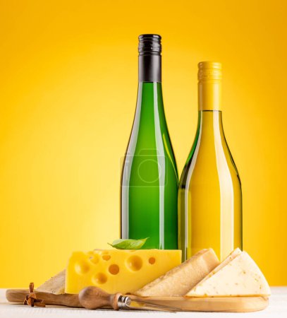 Foto de Various cheese on board and white wine. Over yellow background with copy space - Imagen libre de derechos