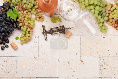 Foto de Copas de vino, botellas y uvas. Piso con espacio de copia - Imagen libre de derechos