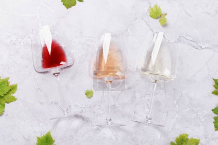 Foto de Copas y botellas de vino blanco, rosa y tinto. Puesta plana - Imagen libre de derechos