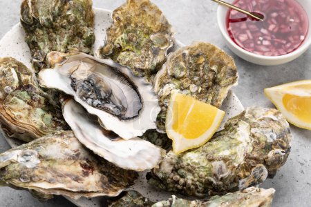 Téléchargez les photos : Fresh oysters with lemons and sauce. Closeup - en image libre de droit
