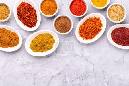 Photo for Various dried spices in small bowls on stone table - Royalty Free Image