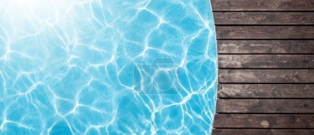 Téléchargez les photos : Piscine terrasse en bois et eau bleue de la piscine. Vue du dessus plat avec espace de copie - en image libre de droit