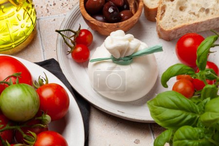 Burrata cheese, various tomatoes and olives. Italian cuisine