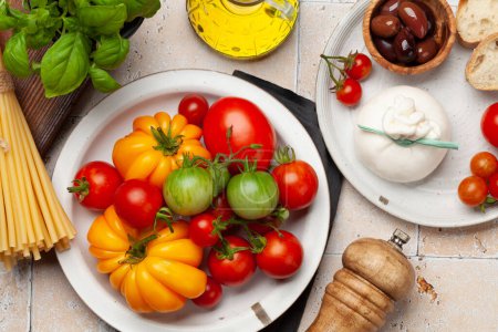 Téléchargez les photos : Various tomatoes, olives and burrata cheese. Italian cuisine. Flat lay - en image libre de droit